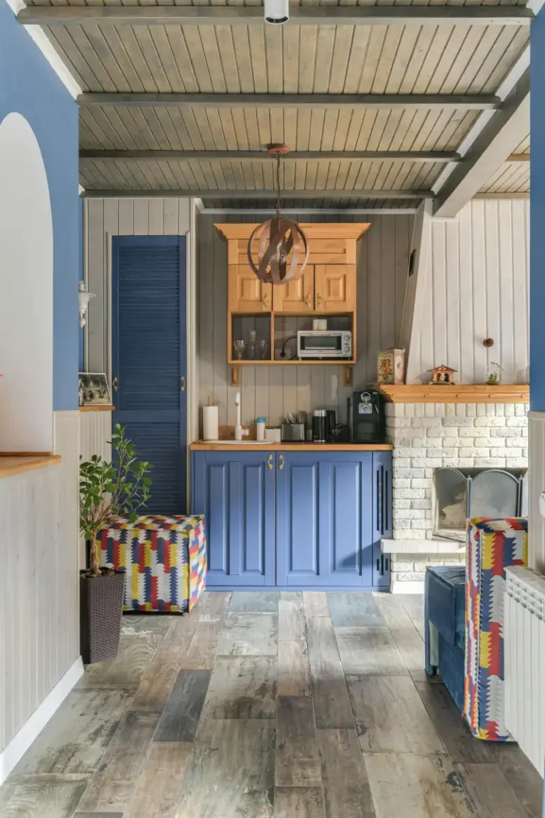 A modern kitchen featuring a blue cabinets with wood countertops